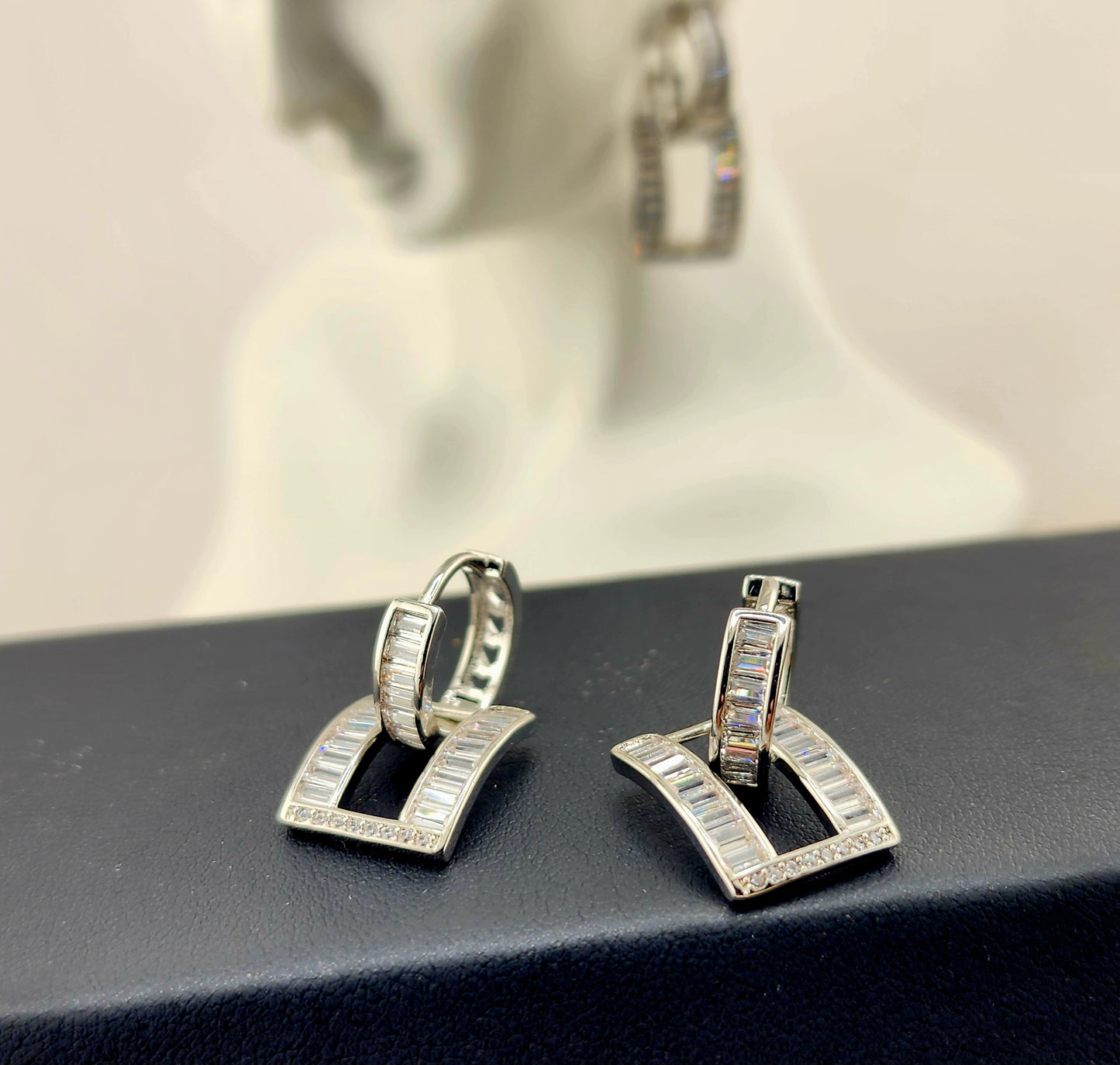 Platinum plated earrings with baguette-cut cubic zirconia in a bold geometric drop design.
